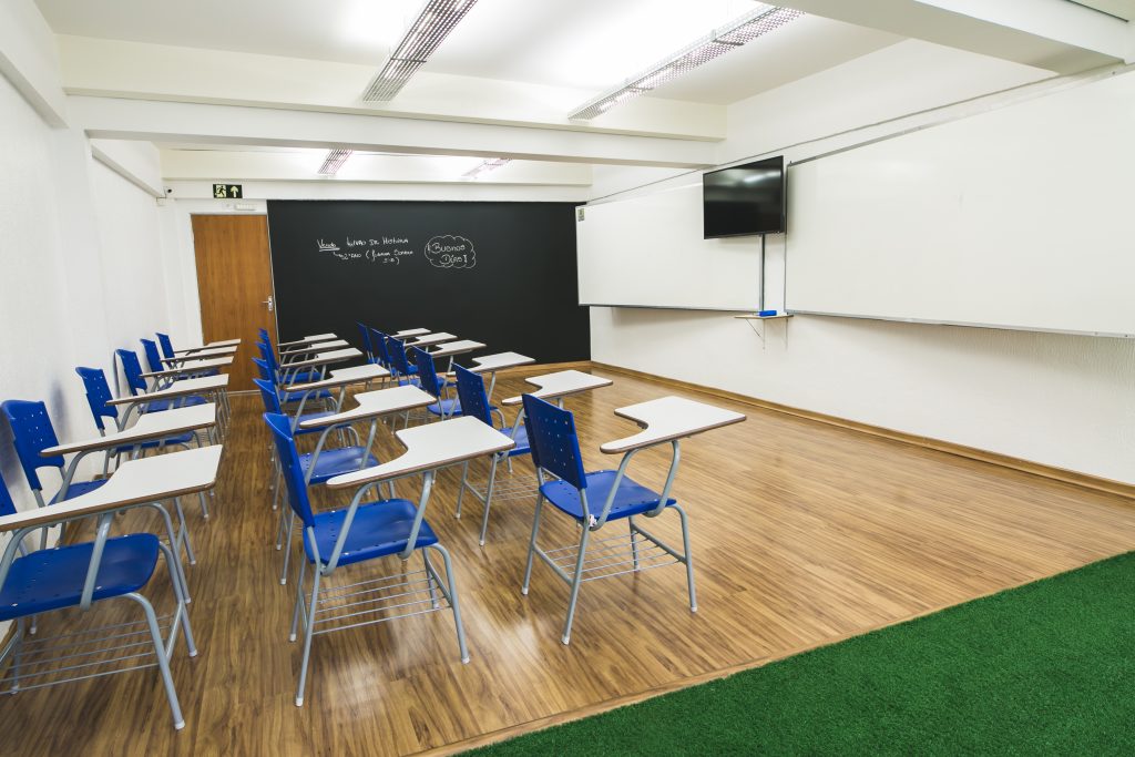 Sala de aula moderna, com TV e carteiras ergonômicas, auxilia no desempenho escolar