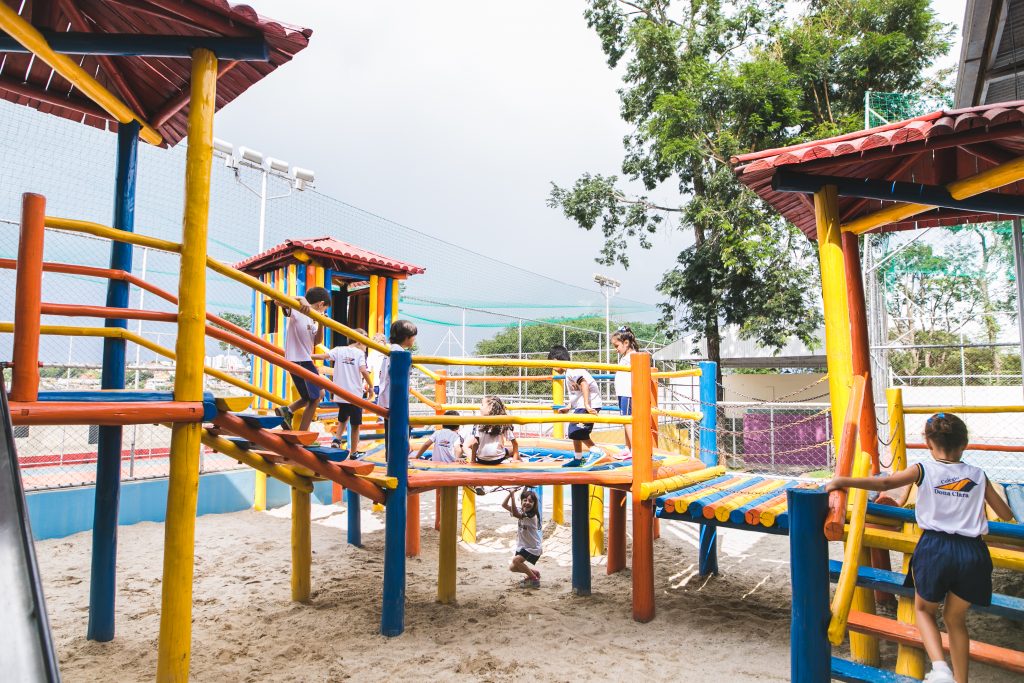 Crianças brincando no parquinho da escola se tornam mais sociáveis e desenvolvem a inteligência emocional na infância